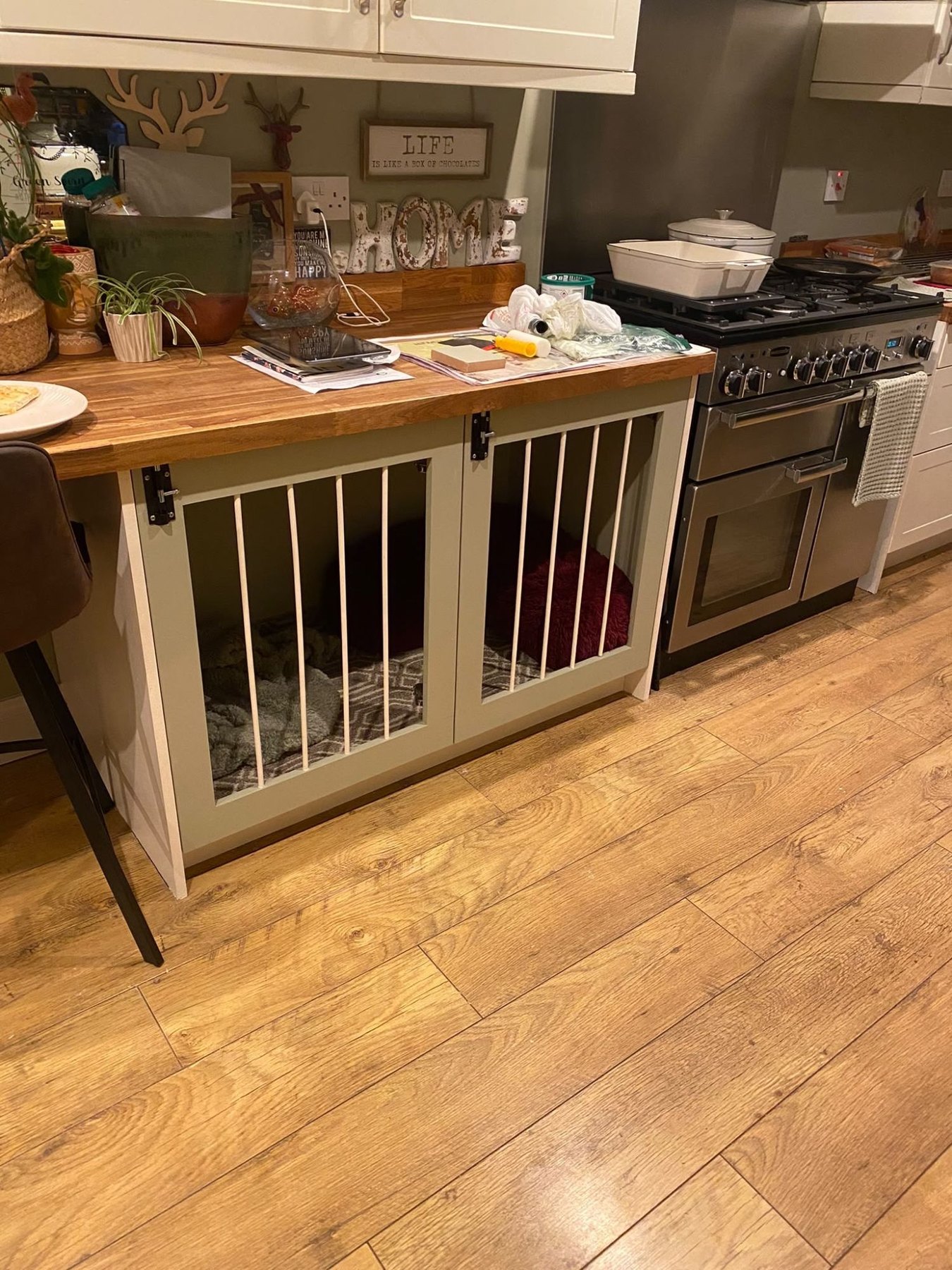A kitchen island with built-in dog crates beneath the oak worktop, sitting alongside the range cooker